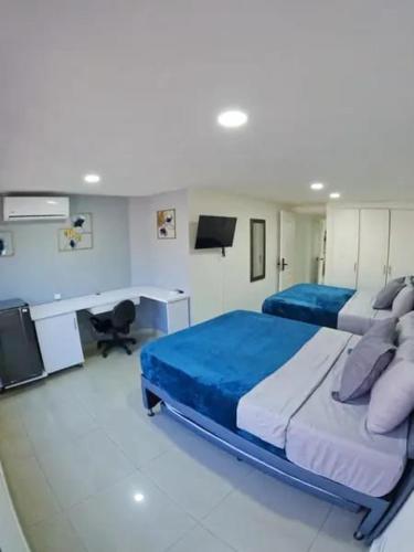 a bedroom with two beds and a desk in it at Glam House Hotel in Medellín