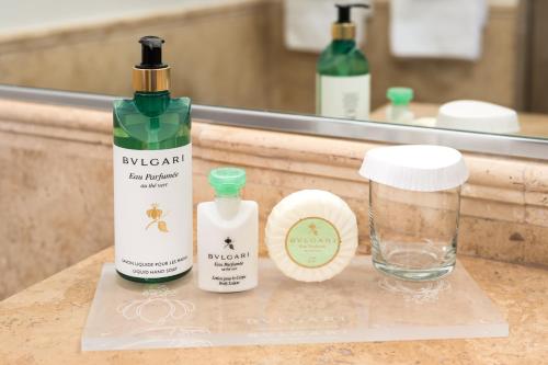 a bathroom counter with two bottles of soap and a glass at Windsong on the Reef in Grace Bay