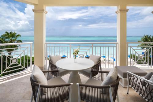 a balcony with a table and chairs and the ocean at Windsong on the Reef in Grace Bay