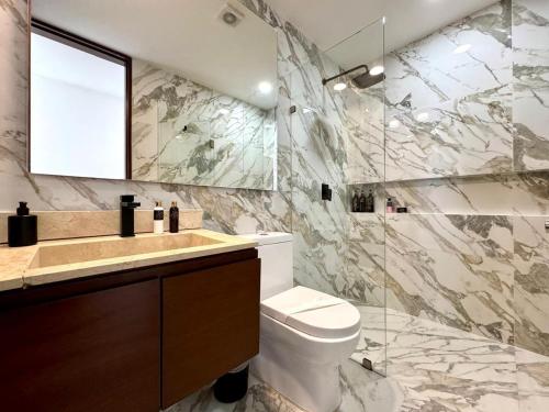 a bathroom with a toilet and a sink and a mirror at Beautiful sea view apartment in the Hotel Zone Cancun in Cancún