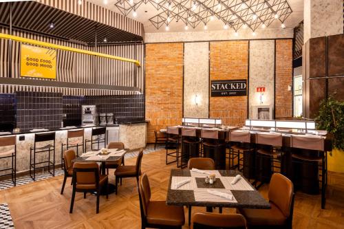 a restaurant with tables and chairs and a bar at Hard Rock Hotel & Casino Punta Cana - All Inclusive in Punta Cana