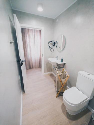 a bathroom with a white toilet and a sink at Aurora Hostel in Angra do Heroísmo