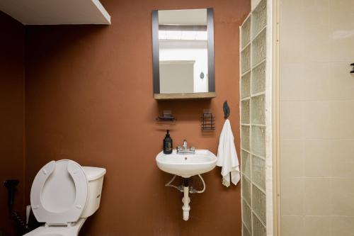 a bathroom with a toilet and a sink and a mirror at Habitación compartida en el Centro de Cancún in Cancún