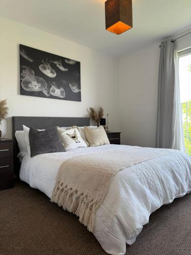 una camera da letto con un grande letto bianco con una finestra di Cozy room in a shared flat by Etihad and Coop Live Arena a Manchester