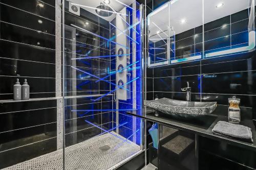 une salle de bain avec une douche en verre avec un lavabo dans l'établissement Le Malefique - Disney - 6 pers - Parking Gratuit, à Chessy