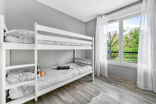 - une chambre blanche avec des lits superposés et une fenêtre dans l'établissement Le Malefique - Disney - 6 pers - Parking Gratuit, à Chessy