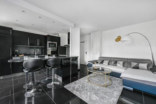 une cuisine et un salon avec un canapé et une table dans l'établissement Le Malefique - Disney - 6 pers - Parking Gratuit, à Chessy