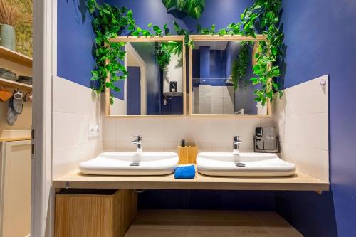 une salle de bain avec deux lavabos et un miroir dans l'établissement Boho Chic Apartment in Old Town, à Nice