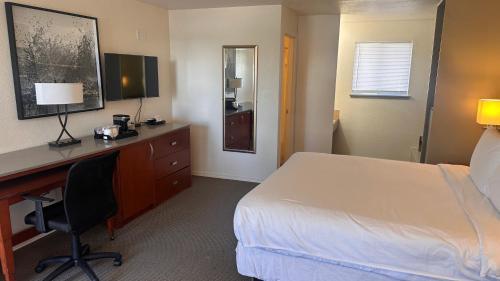a hotel room with a bed and a desk and a bed and a desk at Lakeshore Inn Water Front in Moses Lake