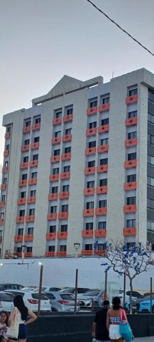 a large apartment building with people sitting in front of it at Hotel Tabajara Apto 406 in Fortaleza