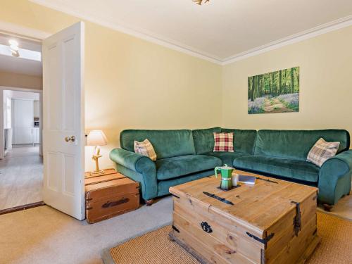 a living room with a green couch and a coffee table at 3 Bed in Kirriemuir 37440 in Kirriemuir