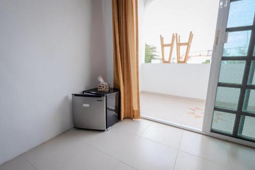 a small refrigerator in a room with a large window at Habitación compartida en el Centro de Cancún in Cancún