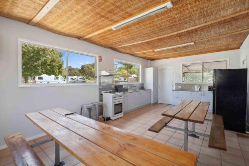 a large kitchen with a wooden table in a room at Wodonga Holiday Park in Wodonga