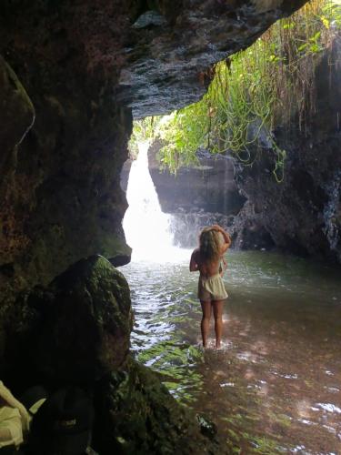 a little girl standing in the water in a cave at Padi Bungalow in Tetebatu