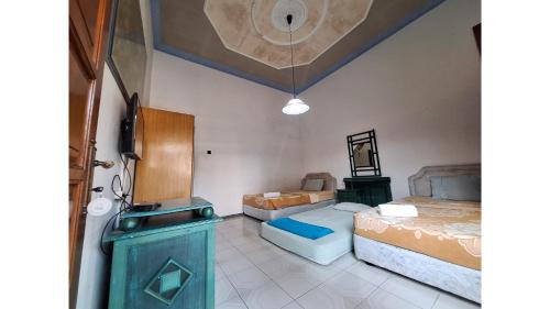 a room with two beds and a sink in it at PLUM Hotel Palereman Batu in Batu