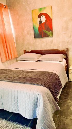 イリャベラにあるVilamaruá apartamento próximo da praia do Perequêのベッドルーム1室(鳥の写真付)