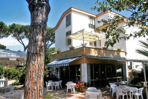 un edificio con tavoli, sedie e un albero di Hotel Anna a Terracina