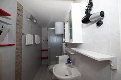 a white bathroom with a toilet and a sink at Family-friendly apartments with swimming pool Lic, Gorski kotar - 23685 in Fužine