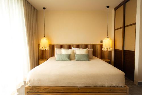 a bedroom with a large white bed with two pillows at Jungle Sunset Penthouse in Tulum with Private Pool, 5 Min from Beach in Tulum