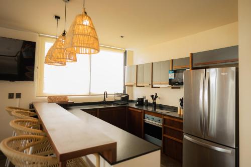 a kitchen with a stainless steel refrigerator and a window at Jungle Sunset Penthouse in Tulum with Private Pool, 5 Min from Beach in Tulum