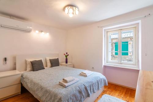 una camera da letto con un letto e una finestra di Holiday house with a parking space Pag - 19852 a Pag