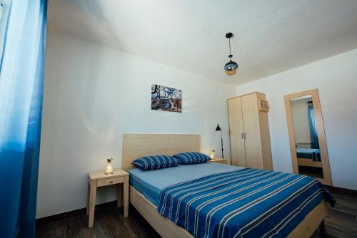 ein Schlafzimmer mit einem Bett mit einer blau gestreiften Decke in der Unterkunft Holiday house with a parking space Imotski, Zagora - 24482 in Imotski