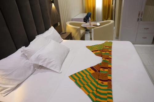 a white bed with a colorful blanket on top of it at Texas Royal Lodge Hotel in Janman