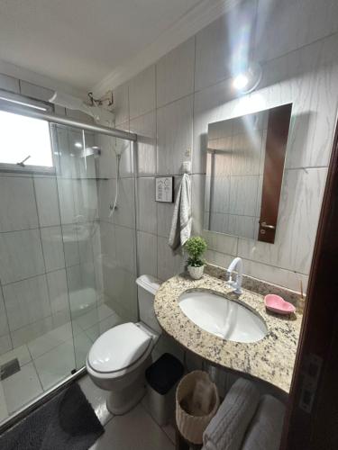 Un baño con lavabo, inodoro y ducha. en Apartamento aconchegante no Recreio, en Río de Janeiro