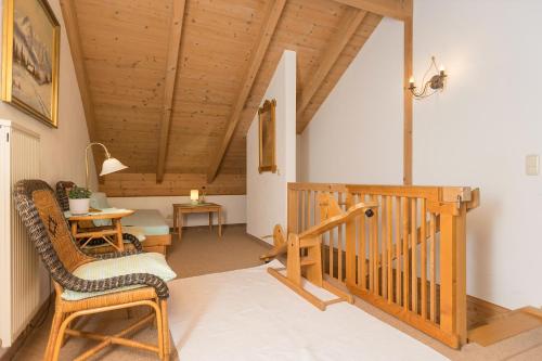 a room with a staircase and a chair and a table at Ferienhaus Alp Chalet in Kochel