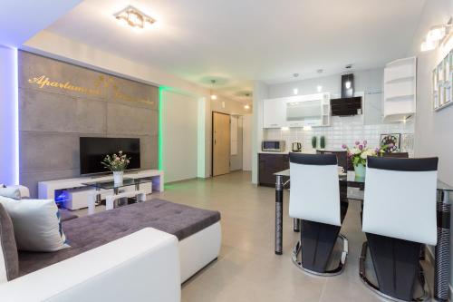 a living room with a couch and a dining room at VIP Apartamenty Stara Polana in Zakopane
