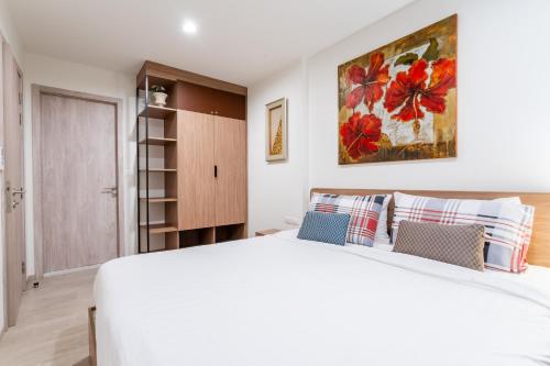 a bedroom with a white bed and a painting on the wall at Hua Hin La Casita Beautiful Two Bedroom Condo With Great Views in Hua Hin