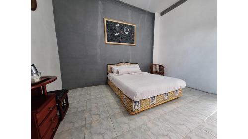 a bedroom with a bed and a picture on the wall at PLUM Hotel Palereman Batu in Batu