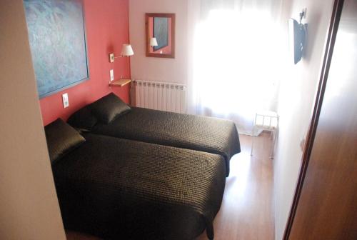 a bedroom with a black bed in a room at Hostal Delgado in Benabarre