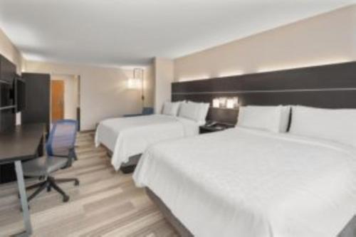 a hotel room with two beds and a desk at Holiday Inn Express Hotel & Suites Drums-Hazelton by IHG in Drums