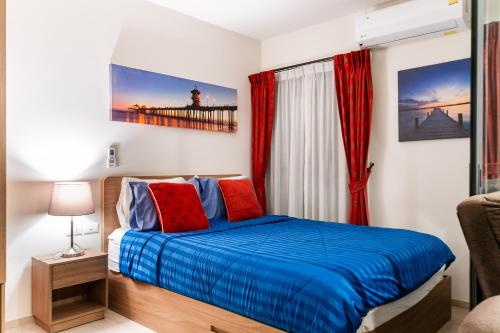 a bedroom with a bed with blue and red pillows at Hua Hin La Casita Beautiful Two Bedroom Condo With Great Views in Hua Hin