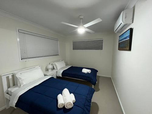 a bedroom with two beds and a ceiling fan at Happy Haven at Eight Mile in Brisbane