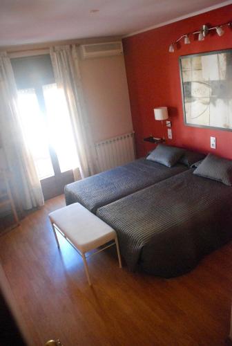 a room with two beds and a table in it at Hostal Delgado in Benabarre