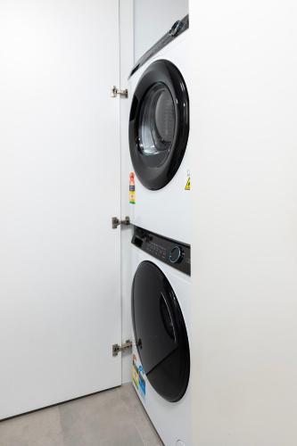 a washer and dryer on a door in a room at Wellness and Style - 2BR Apartment with Pool, Hot Tub and Gym in Melbourne