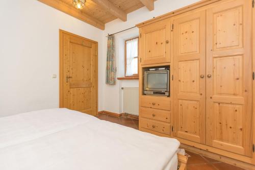a bedroom with a bed and a tv on a cabinet at Ferienhaus Alp Chalet in Kochel