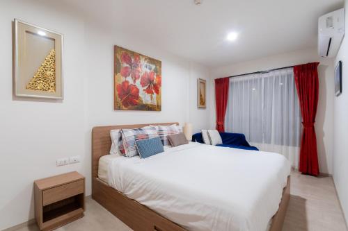 a bedroom with a bed and a window with red curtains at Hua Hin La Casita Beautiful Two Bedroom Condo With Great Views in Hua Hin