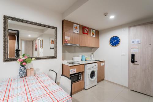 a small kitchen with a table and a washing machine at Hua Hin La Casita Beautiful Two Bedroom Condo With Great Views in Hua Hin
