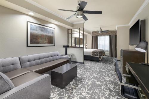 a living room with a couch and a bed at Best Western Premier Crown Chase Inn & Suites in Denton