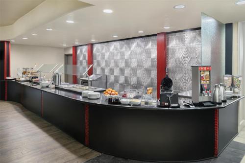 a restaurant with a counter with food on it at Best Western Premier Crown Chase Inn & Suites in Denton