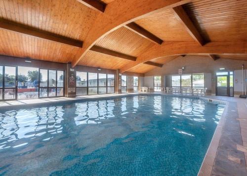 a large indoor swimming pool with a wooden ceiling at Riverside Caravan Holiday Park in Bognor Regis