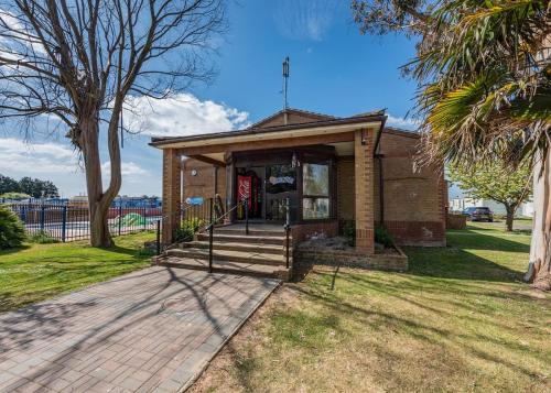 a small brick building with a porch and stairs at Riverside Caravan Holiday Park in Bognor Regis
