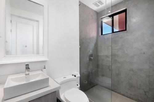 Un baño con inodoro, lavabo y ducha. en Bougainvillea 4315 Ph- Luxury 3 Bedroom Ocean View Resort Condo, en Brasilito
