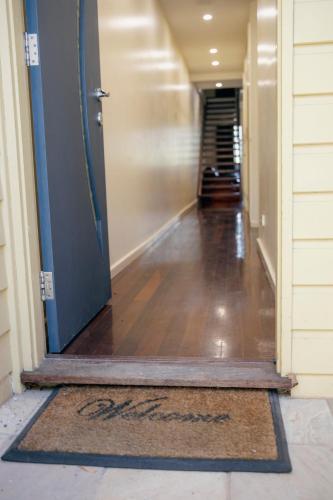 a hallway with a blue door and a rug at Halls Gap Escape Townhouses in Halls Gap