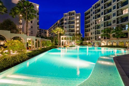 a swimming pool at night with tall buildings at Hua Hin La Casita Beautiful Two Bedroom Condo With Great Views in Hua Hin
