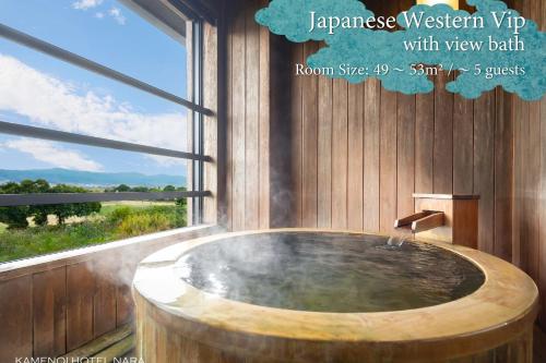 a wooden bathroom with a wooden tub with a window at KAMENOI HOTEL Nara in Nara