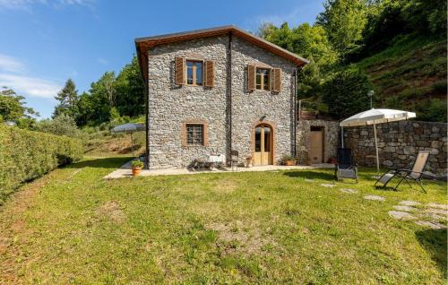 a small stone house with a grassy yard at Nice Apartment In Borgo A Mozzano in Borgo a Mozzano